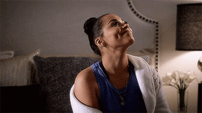 A Woman Is Sitting On A Couch And Looking Up At The Sky . GIF