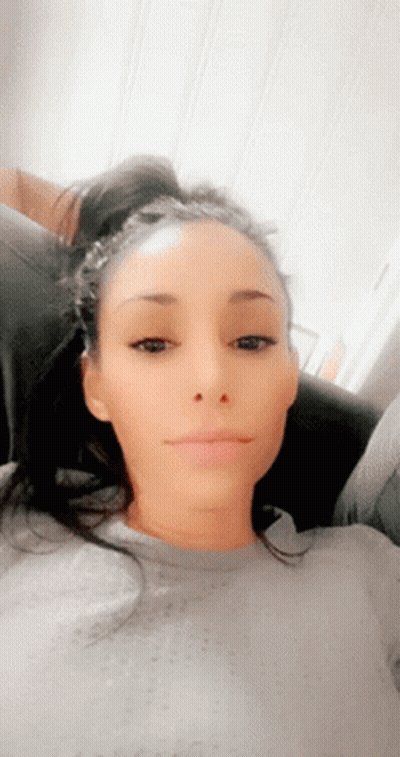 A Woman Is Sitting On A Couch And Making A Funny Face GIF