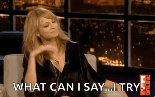 A Woman Is Sitting On A Couch And Saying What Can I Say ... I Try ! GIF