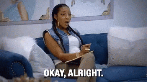 A Woman Is Sitting On A Couch Holding A Clipboard And Saying `` Okay , Alright '' . GIF