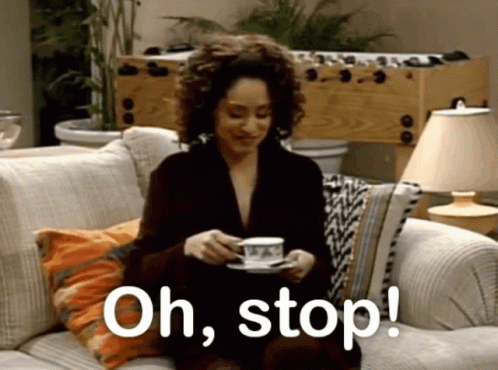 A Woman Is Sitting On A Couch Holding A Cup Of Coffee And The Words Oh Stop Are Visible GIF