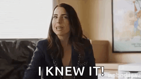 A Woman Is Sitting On A Couch In A Living Room And Saying `` I Knew It ! '' GIF
