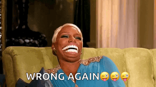 A Woman Is Sitting On A Couch Laughing With The Words Wrong Again Written Above Her . GIF