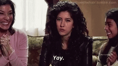 A Woman Is Sitting On A Couch Talking To Two Other Women . GIF