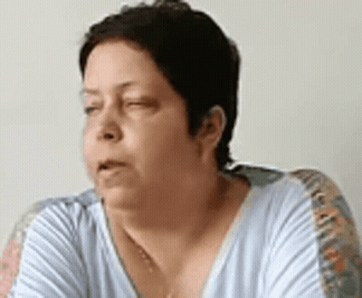 A Woman Is Sitting On A Couch With Her Eyes Closed And Her Mouth Open . GIF