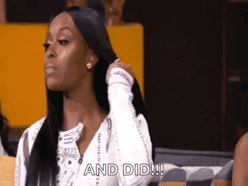A Woman Is Sitting On A Couch With Her Hand On Her Hair And The Words " And Did " Written On The Bottom GIF