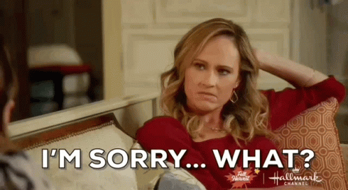 A Woman Is Sitting On A Couch With Her Hand On Her Head And Saying `` I 'M Sorry ... What ? '' GIF