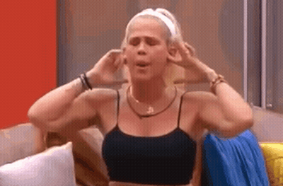 A Woman Is Sitting On A Couch With Her Hands On Her Ears . GIF