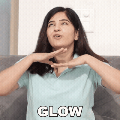 A Woman Is Sitting On A Couch With Her Hands On Her Face And The Word Glow In Front Of Her GIF