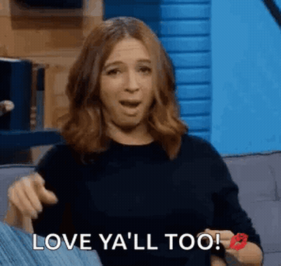 A Woman Is Sitting On A Couch With Her Mouth Open And A Kiss On Her Cheek . GIF