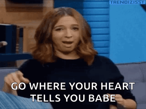 A Woman Is Sitting On A Couch With Her Mouth Open And Says Go Where Your Heart Tells You Babe . GIF