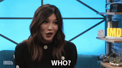 A Woman Is Sitting On A Couch With Her Mouth Open And Says Who GIF