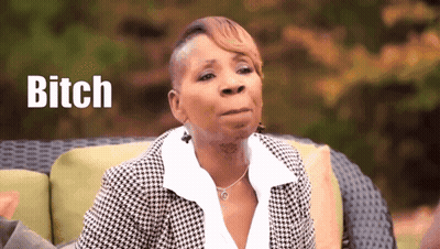 A Woman Is Sitting On A Couch With The Word Bitch Written In The Background GIF