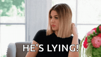 A Woman Is Sitting On A Couch With The Words `` He 'S Lying '' Written On The Screen . GIF