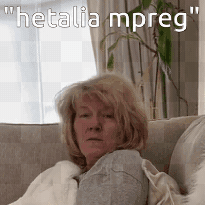 A Woman Is Sitting On A Couch With The Words " Hetalia Mpreg " On The Bottom GIF