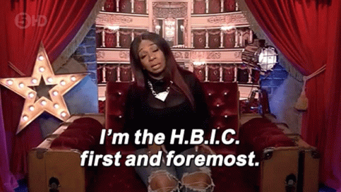 A Woman Is Sitting On A Couch With The Words I 'M The H.b.i.c First And Foremost GIF