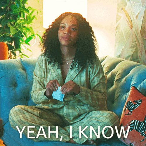 A Woman Is Sitting On A Couch With The Words Yeah I Know On The Bottom GIF