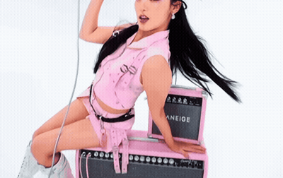 A Woman Is Sitting On A Pink Amplifier That Says Aneige On It GIF