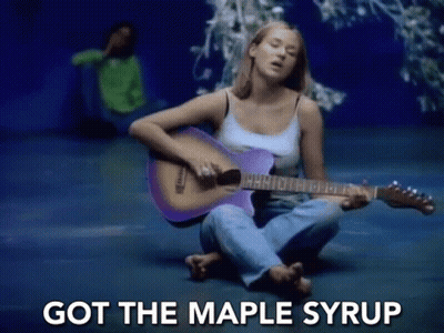 A Woman Is Sitting On The Floor Playing A Purple Guitar And Singing . GIF