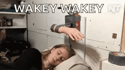 A Woman Is Sleeping In A Bed With A Machine On Her Arm That Says Wakey-Wakey . GIF