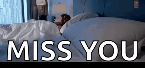 A Woman Is Sleeping In A Bed With The Words Miss You Written Above Her GIF