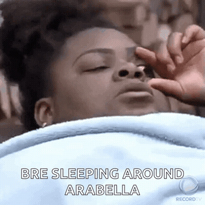 A Woman Is Sleeping In Bed With Her Eyes Closed And Her Hand On Her Face . GIF