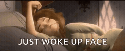a woman is sleeping in bed with the words `` just woke up face '' written on the bottom .