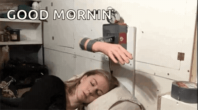 A Woman Is Sleeping On A Pillow With A Robotic Arm Reaching Out Towards Her . GIF