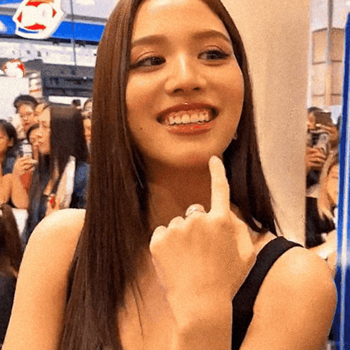 A Woman Is Smiling And Giving The Middle Finger In Front Of A Dairy Queen Sign GIF