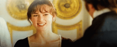 A Woman Is Smiling And Looking At A Man In A Room . GIF