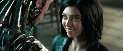A Woman Is Smiling And Looking At A Robot GIF