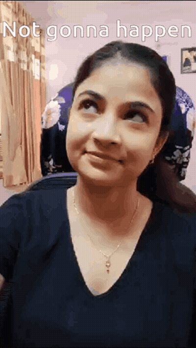 A Woman Is Smiling And Looking Up At The Sky While Wearing A Black Shirt And Necklace . GIF
