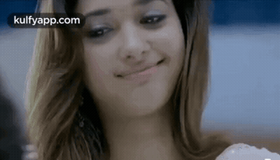 A Woman Is Smiling And Making A Funny Face . GIF