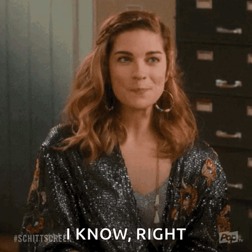 A Woman Is Smiling And Saying `` I Know , Right '' While Holding Her Hand To Her Face . GIF