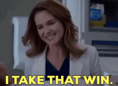 A Woman Is Smiling And Saying `` I Take That Win '' . GIF