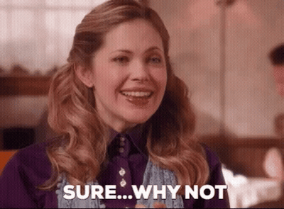 A Woman Is Smiling And Saying `` Sure Why Not '' . GIF