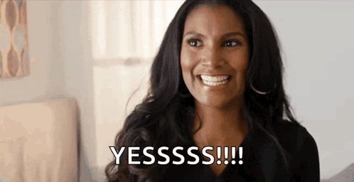A Woman Is Smiling And Saying Yesssss !!! In A Bedroom . GIF