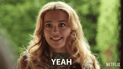 A Woman Is Smiling And Says Yeah In Front Of A Green Background GIF