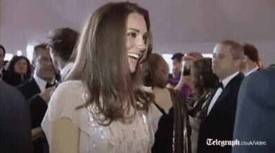 A Woman Is Smiling In A Crowd Of People At A Party . GIF