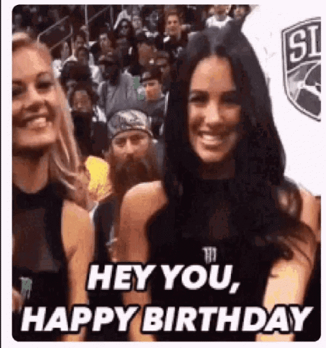 A Woman Is Smiling In Front Of A Crowd And Says `` Hey You , Happy Birthday '' While Standing Next To Another Woman . GIF