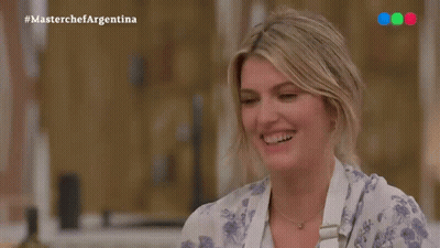A Woman Is Smiling In Front Of A Masterchef Argentina Sign GIF