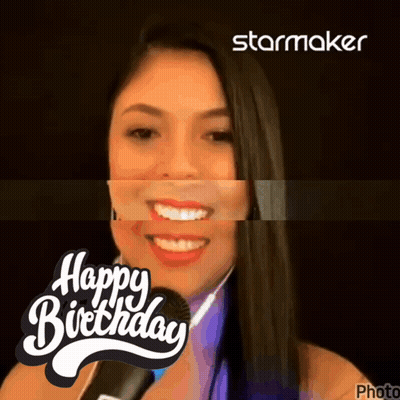 A Woman Is Smiling In Front Of A Microphone With The Words Happy Birthday Behind Her GIF