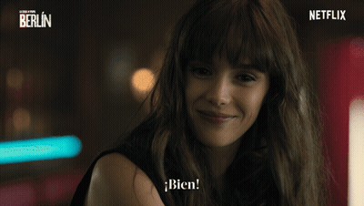A Woman Is Smiling In Front Of A Netflix Banner GIF