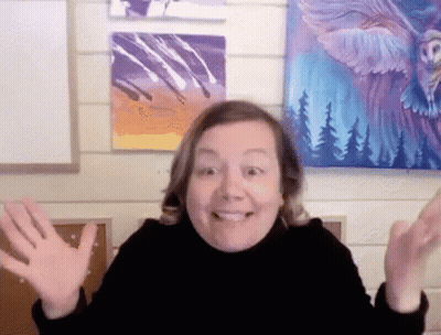 A Woman Is Smiling In Front Of A Painting Of An Eagle On A Wall GIF