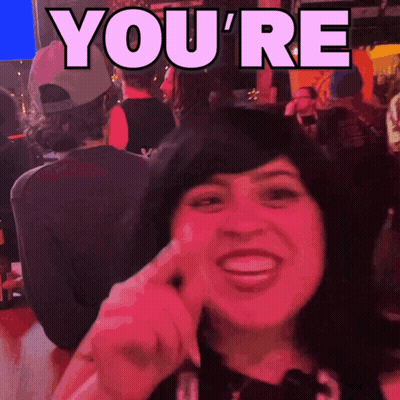 A Woman Is Smiling In Front Of A Sign That Reads You 'Re GIF
