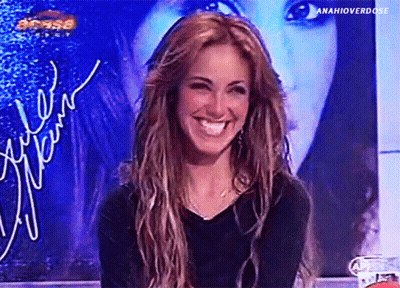 A Woman Is Smiling In Front Of A Sign That Says ' Anahioverdose ' On It GIF