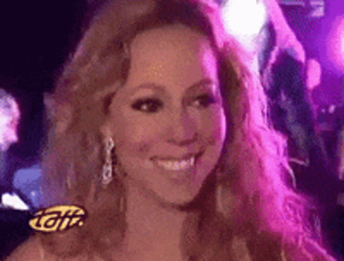 A Woman Is Smiling In Front Of A Sign That Says ' Gif ' GIF