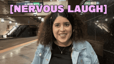 A Woman Is Smiling In Front Of A Sign That Says [ Nervous Laugh ] GIF