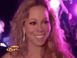A Woman Is Smiling In Front Of A Sign That Says ' Tgiv ' On It GIF