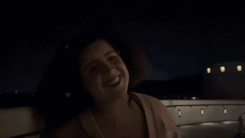 A Woman Is Smiling In The Dark And The Name Shagarita Is On The Bottom Right GIF